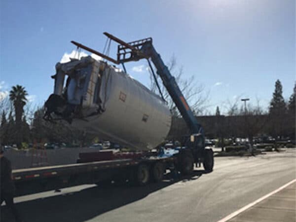 Commercial building facade being removed by heavy equipment