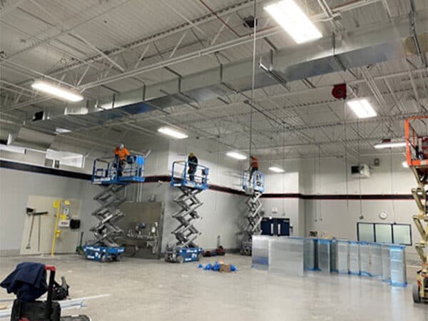 Crews working from lifts inside a large commercial interior
