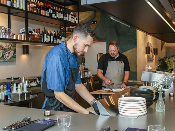 Restaurant staff preparing dishes behind an open counter