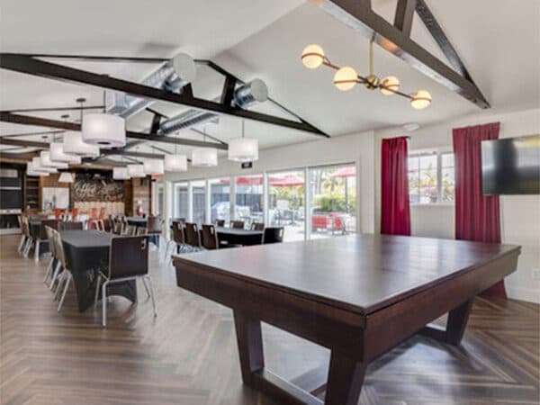 Clubhouse event room with tables, seating, and exposed beams